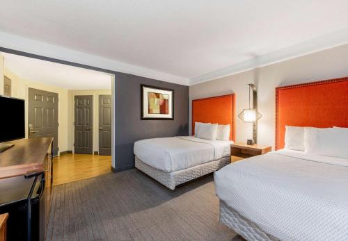 a hotel room with two beds and a flat screen tv at La Quinta by Wyndham New Orleans Downtown in New Orleans