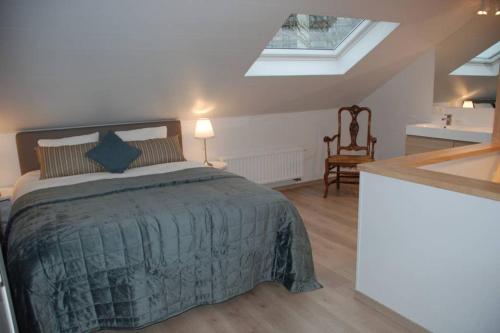 ein Schlafzimmer mit einem Bett und ein Bad mit einem Fenster in der Unterkunft Aylise vakantiehuis in Ostende