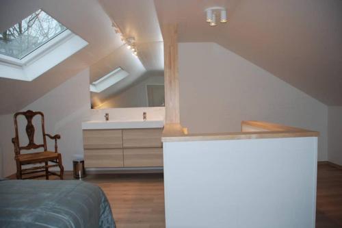 Schlafzimmer im Dachgeschoss mit einem Bett und einem Waschbecken in der Unterkunft Aylise vakantiehuis in Ostende
