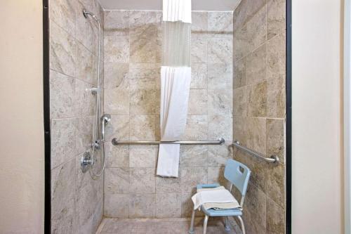 a shower with a blue chair in a bathroom at La Quinta by Wyndham Ruidoso Downs in Ruidoso Downs