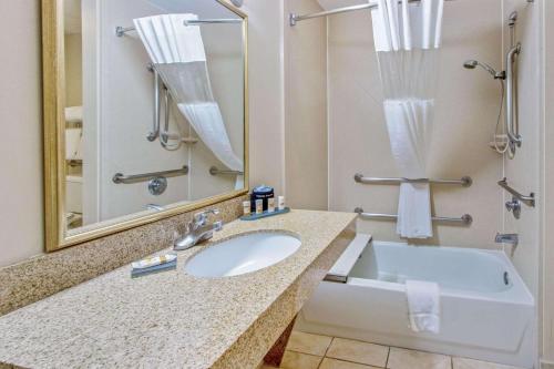 ein Badezimmer mit einem Waschbecken, einem Spiegel und einer Badewanne in der Unterkunft La Quinta by Wyndham Ruidoso Downs in Ruidoso Downs