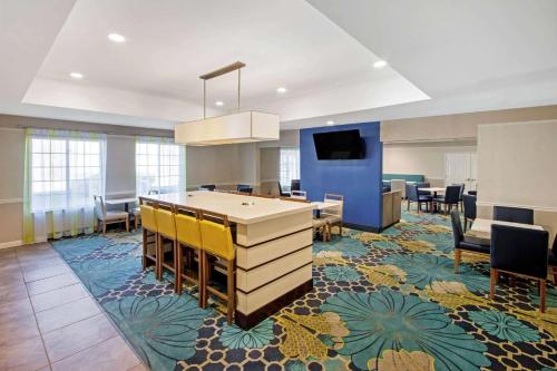 a lobby with a desk and chairs and a tv at La Quinta by Wyndham Ruidoso Downs in Ruidoso Downs