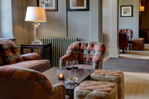 a living room with two chairs and a table with wine glasses at Windmill Village Hotel, Golf Club & Spa, BW Signature Collection in Coventry