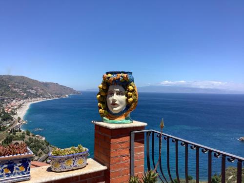 a statue of a head on a balcony overlooking the ocean at B&B Martina in Taormina