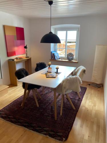 a dining room table with a white horse on a rug at Apartment am Wildbach - Radeln, Wandern, Natur, Urlaub mit Hund in Fischbachau