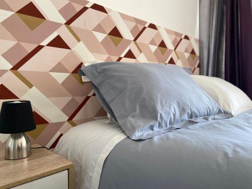 - un oreiller sur un lit avec un mur coloré dans l'établissement Grand studio confortable et spacieux avec terrasse, à Villeneuve-lès-Maguelone