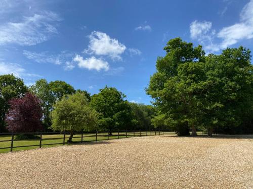 a large park with trees and a fence at George & Dragon Country Pub & Hotel Wolverton Townsend in Tadley