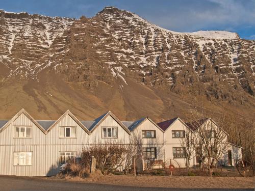 a group of houses in front of a mountain at Skyrhusid Guesthouse in Hali