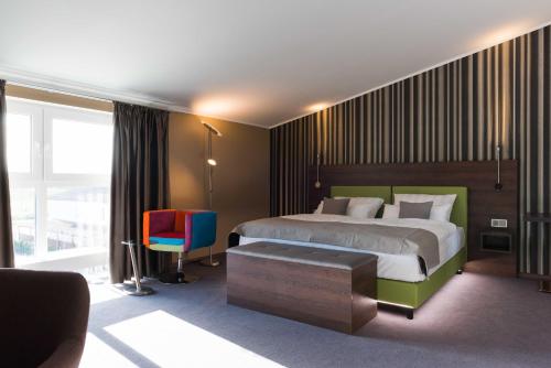 een hotelkamer met een bed en een stoel bij Steinberger Hof in Dietzenbach