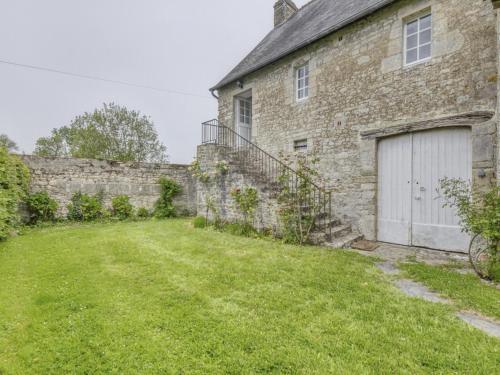 ein altes Backsteinhaus mit Garage und Hof in der Unterkunft Holiday Home Omaha Beach with Garden in Aignerville