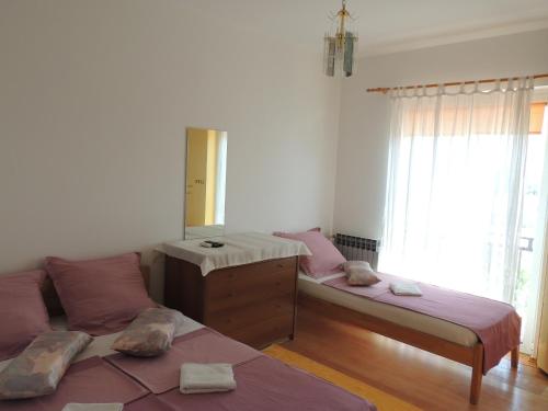 sypialnia z 2 łóżkami, komodą i lustrem w obiekcie Villa Šutić w mieście Promajna
