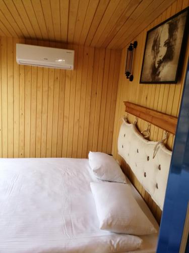 a bedroom with a white bed and a fan at Pamera Garden Hotel in Kılıçlı