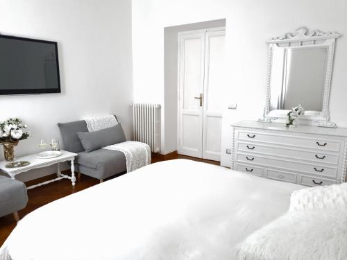 a white bedroom with a bed and a dresser at Glory House Trastevere in Rome