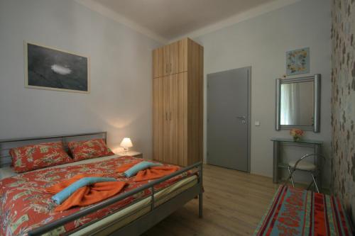 a bedroom with a bed with orange sheets and a cabinet at Apartment No 21 - I P Pavlova 34 in Karlovy Vary