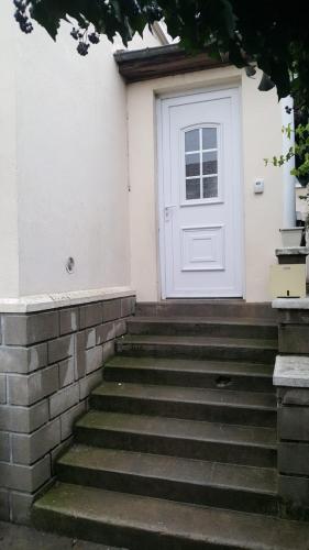 uma porta branca com escadas em frente a uma casa em GRAND APPARTEMENT AVEC TERRASSE & JARDIN A 5 minutes de PARIS em Cachan