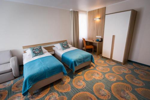 カルビアにあるWilla Jagodaのベッド2台とデスクが備わるホテルルームです。