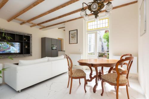 a living room with a table and chairs and a couch at The Golden Gardens - R.Q.C. in The Hague