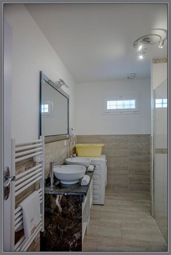 une salle de bain avec un lavabo, des toilettes et un miroir dans l'établissement Belvillas, à Montauroux