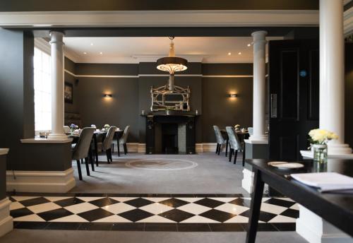 a dining room with a table and chairs and a fireplace at Poets House in Ely