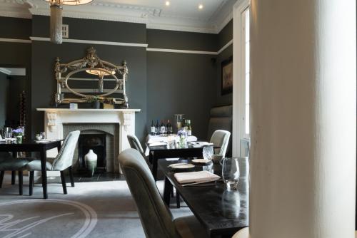 a dining room with a table and a fireplace at Poets House in Ely