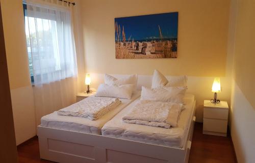 a bedroom with a bed with white sheets and pillows at Ferienapartment Sonnensegler Insel Usedom in Karlshagen