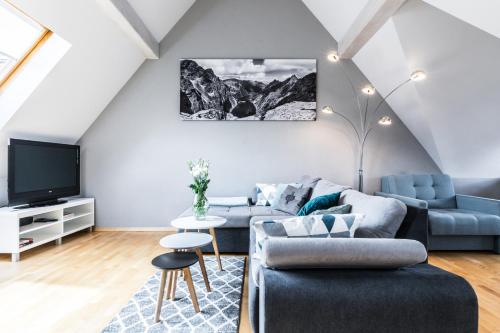 een woonkamer met een bank en een tv bij Apartament Irys in Zakopane