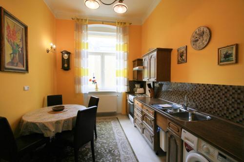 eine Küche mit einem Tisch, einem Waschbecken und einem Fenster in der Unterkunft Apartment No. 20 Jaltská 3 in Karlsbad