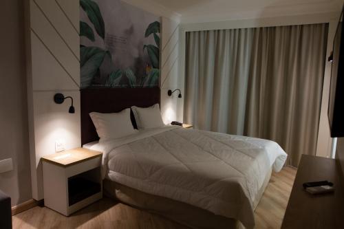 a hotel room with a bed and a window at Bristol International Guarulhos in Guarulhos