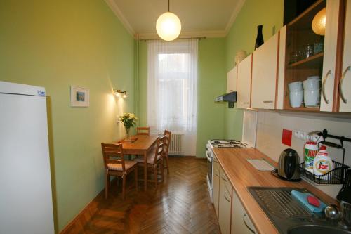 une cuisine avec une table et une cuisine avec des murs verts dans l'établissement Apartment No. 25 T.G.Masaryka 13 s výtahem, à Karlovy Vary