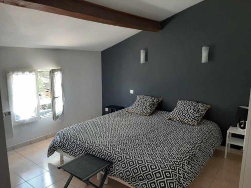 a bedroom with a bed with a black and white comforter at Le Domaine Leylandy in Saint-Sulpice-de-Royan