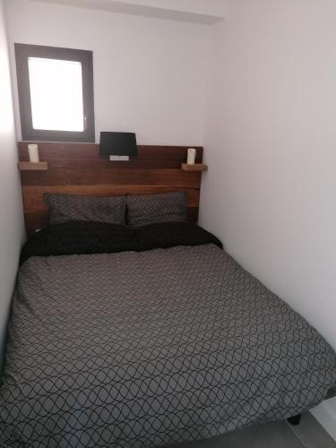 une chambre avec un lit et une fenêtre dans l'établissement Les Mégalithes, à Sète