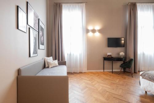 a bedroom with a couch and a bed and a window at Hotel Palazzo Martinelli Dolfin in Venice
