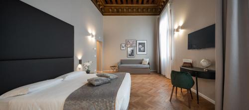 una camera con un grande letto e un divano di Hotel Palazzo Martinelli Dolfin a Venezia