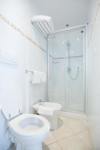 a white bathroom with a toilet and a shower at Hotel Angelica Firenze in Florence