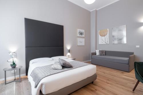 a bedroom with a large white bed and a couch at Hotel Palazzo Martinelli Dolfin in Venice