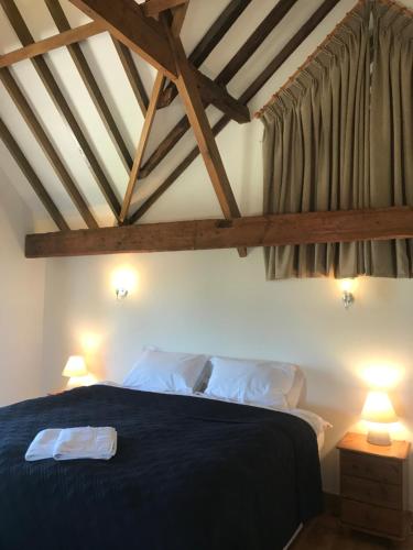 1 dormitorio con 1 cama negra y 2 lámparas en The HopBarn, en Hockerton