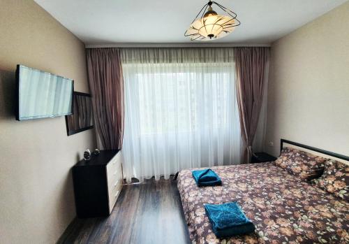 - une chambre avec un lit et une grande fenêtre dans l'établissement Апартамент БОНИТА, à Haskovo