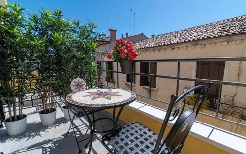 uma varanda com uma mesa e cadeiras. em Grifoni Boutique Hotel em Veneza