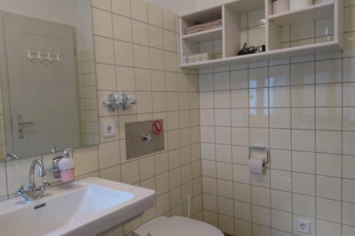 a bathroom with a sink and a toilet and a mirror at Studio in Architeken - Villa in Theaternähe in Meiningen