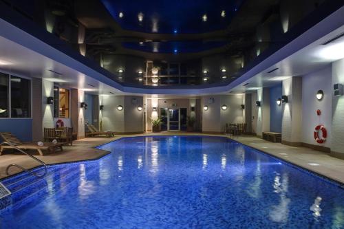 une grande piscine d'eau bleue dans un hôtel dans l'établissement Windmill Village Hotel, Golf Club & Spa, BW Signature Collection, à Coventry