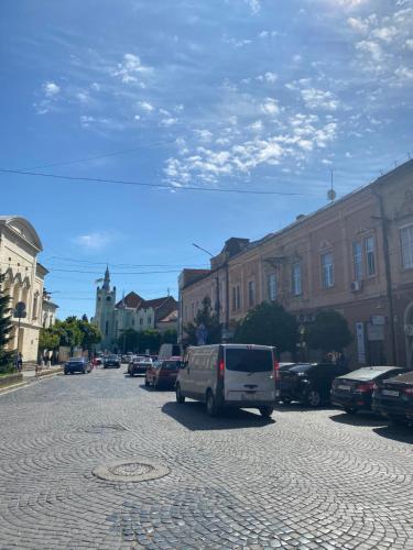 a white van parked on a street with buildings at Apartment suite Mukachevo in Mukacheve