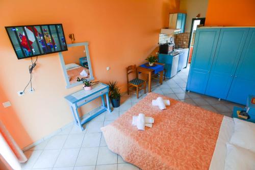 una camera con due letti e una televisione a parete di Panos Apartments a Benitses