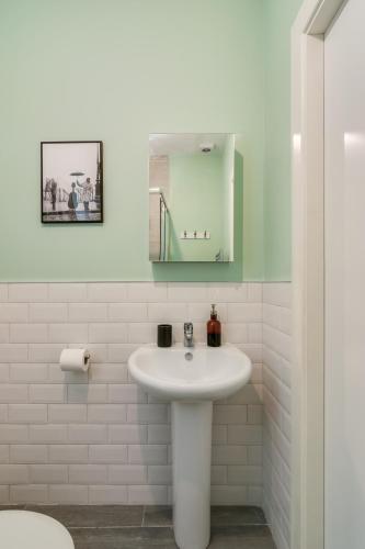 a white bathroom with a sink and a mirror at Wellington Park Boutique Apartments in Belfast
