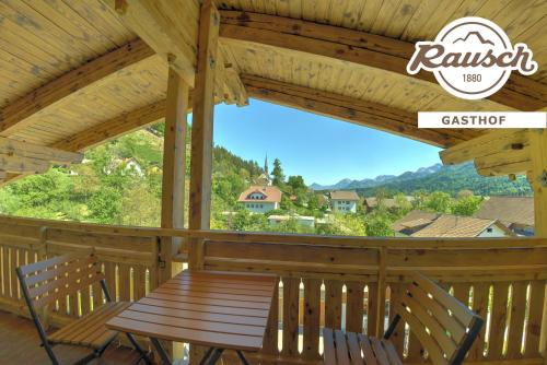 a wooden table and chairs on the porch of a cabin at Alpen Adria Gasthof Rausch in Ledenitzen