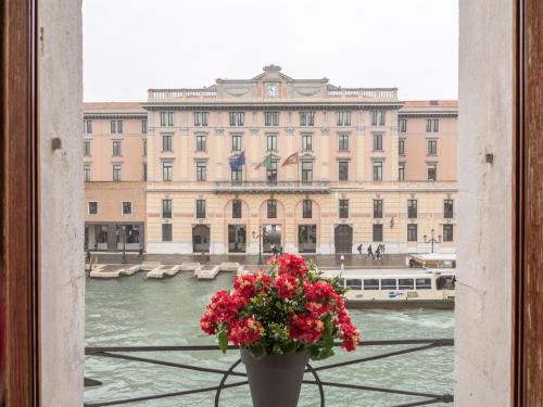 un jarrón con flores delante de un gran edificio en Grand Canal Suite by Wonderful Italy, en Venecia