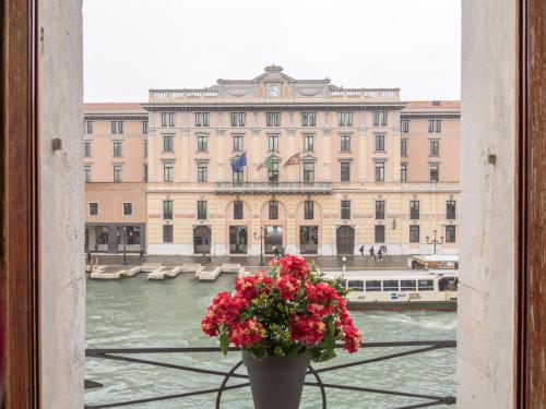 a vase with flowers in front of a large building at Grand Canal Suite by Wonderful Italy in Venice