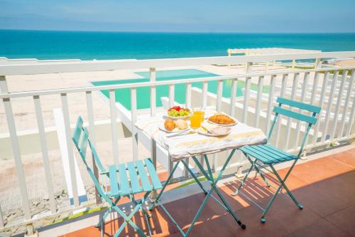 a table and chairs on a balcony with the ocean at Casa da Azenha Terrace Prime in Santa Cruz