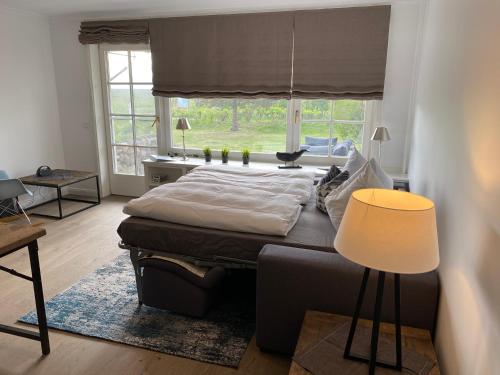ein Schlafzimmer mit einem Bett und einem großen Fenster in der Unterkunft Sylthaus - Appartement in Archsum