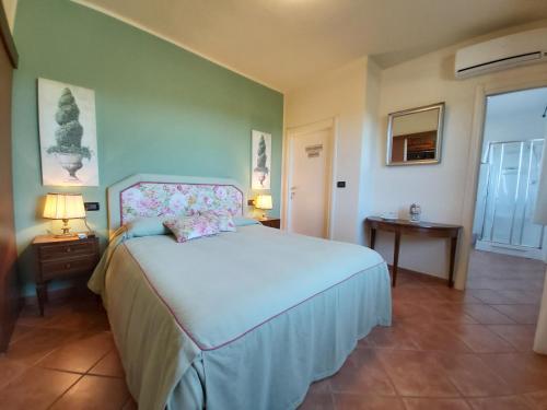 een slaapkamer met een groot wit bed en 2 lampen bij Agriturismo - B&B L'Acquacotta in Castiglione della Pescaia
