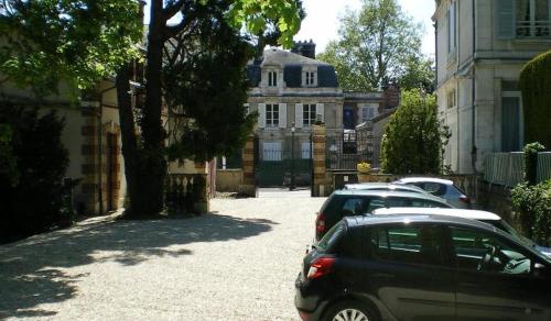 grupa samochodów zaparkowanych przed domem w obiekcie Hôtel Les Maréchaux w mieście Auxerre